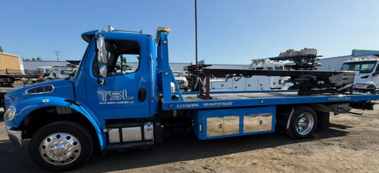 Team Smith Logistics flatbed transporting a stake bed truck